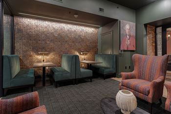 a lounge area with chairs and tables and a painting at The Madison in Columbus, OH 43215